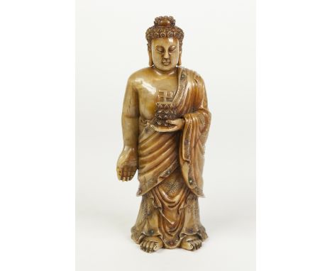 AN AGED CHINESE QING DYNASTY PROBABLY KANGXI (1662-1722) PERIOD CARVED SOAPSTONE FIGURE OF BUDDHA, standing full length weari