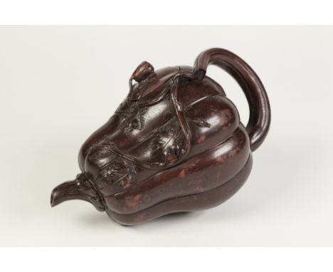 A CHINESE LATE QING DYNASTY YIXING RED EARTHENWARE BROWN PATINATED PUMPKIN FORM TEAPOT, with stack handle, issuing leafy tend