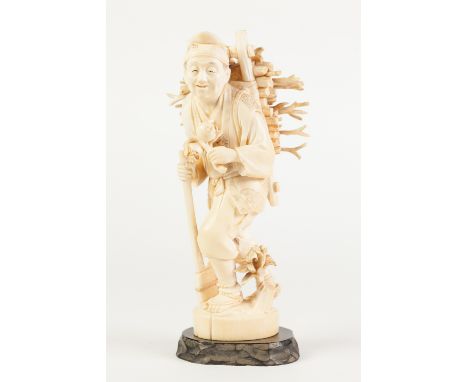 A FINE JAPANESE MEIJI PERIOD ONE PIECE CARVED IVORY OKIMONO, of a peasant male carrying bound faggots of book on his back, a 