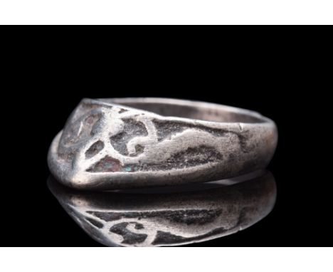 Ca. 1200 AD.A silver archer's ring exhibits a subtle curvature on its exterior, conforming to the contours of the archer's fi