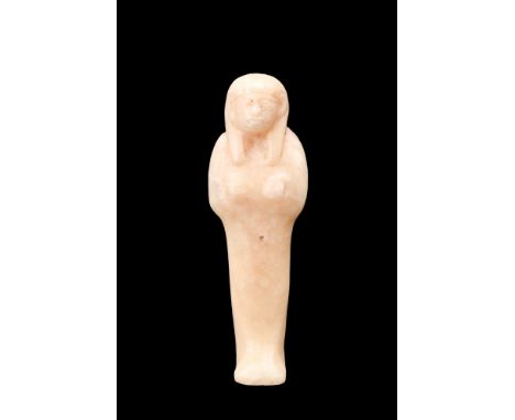 New Kingdom, ca. 1570-1070 BC.An alabaster ushabti. This mummiform figurine stands atop a diminutive, level base, with its ha