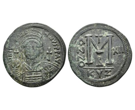 Ca. AD 527-565 .Justinian I Ae. follis, Cyzicus. DN IVSTINIANVS PP AVG; helmeted, cuirassed bust facing, holding cross on glo