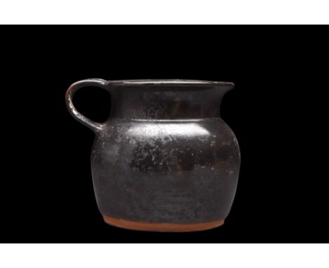 Ca. 450 BC.A black glazed cup with a well-proportioned, bulbous body, gradually tapers to a wide and flat base, while the sho