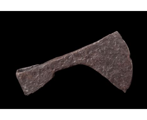 Ca. 900-1100 AD.An iron axe head with an asymmetrical and curved cutting edge that extends below the width of the butt. The a