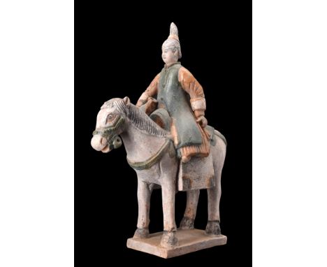 Ca. 1368-1644 AD, or later.A pottery mingqi, portraying a horse with a female rider perched atop. The animal is standing upon