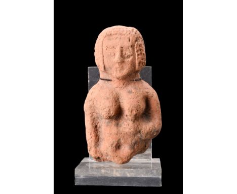 Ca. 1500-1200 BC.Sculpted from fine, thick-walled red terracotta, the relief showcases a slender nude woman with prominent, p