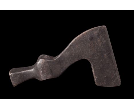 Ca. 1200-1500 AD.An iron axe head displaying an unusual form characterized by a curved upper side, a straight cutting edge, a