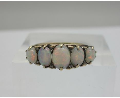 A yellow metal and five stone opal ring set with small diamonds, weight 2.8g, size K