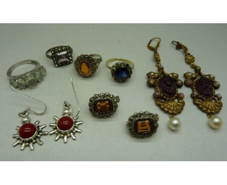 A pair of silver earrings and a silver ring, three other rings and two pairs of earrings