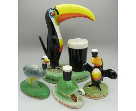 A modern Guinness toucan lamp base and three figures, marked Carlton Ware