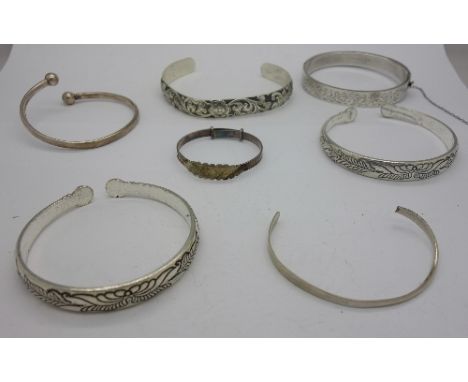 A hallmarked silver bangle and six other bangles, one a/f