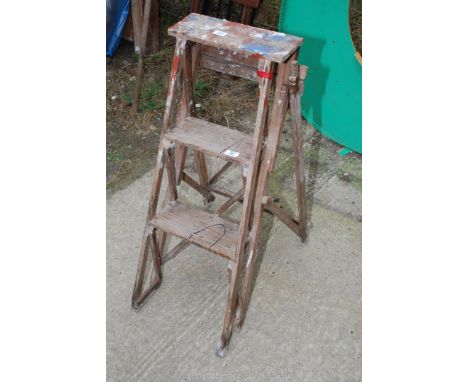 A wooden three rung step ladder.