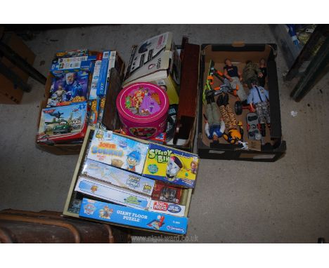 A box of games, giant puzzles and action man figures.