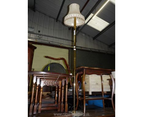 A brass standard lamp and shade.