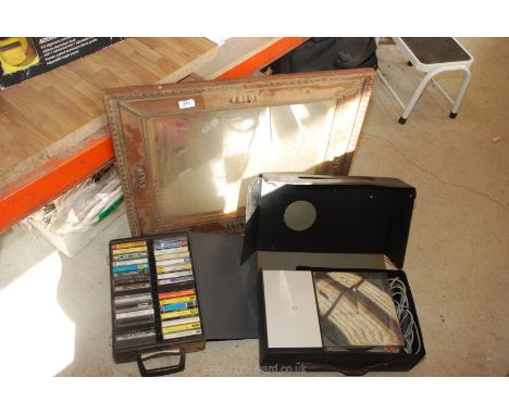 A slide projector, quantity of cassettes and a wooden picture frame.