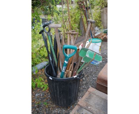 A dustbin of draining rods, fork and spades and leaf grabber.