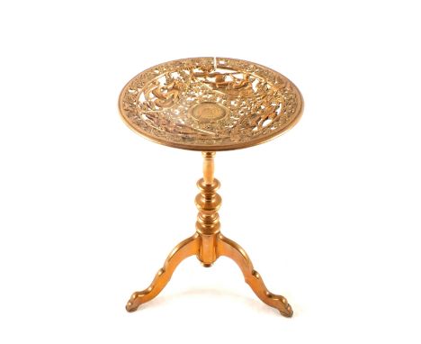 Victorian circular brass trivet in the form of a tripod table, the dished top cast with mythological scenes, 12" high