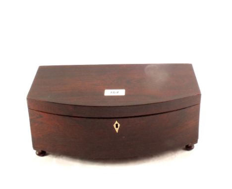 A large 19th Century double compartment bow front rosewood tea caddy on four bun feet, 13" wide