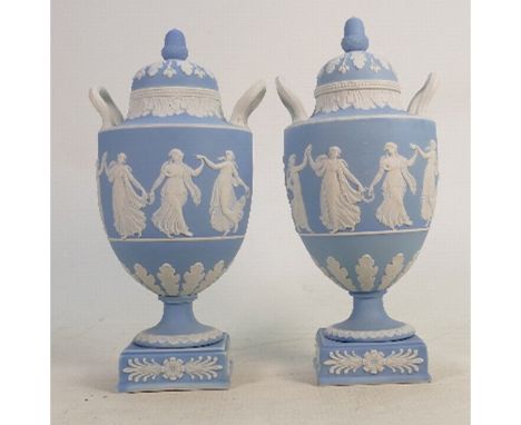 A Wedgwood pair of 19th century light blue dip Jasperware urn &amp; covers: Decorated with dancing hours ladies, height 26cm.