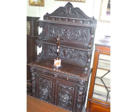 Victorian heavily carved oak two door cabinet having arched shelf back