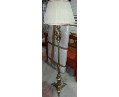 A brass standard lamp moulded with cherubs.
