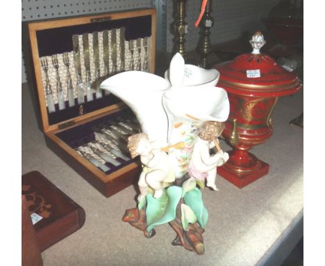 A set of silver plated knives and forks with mother of pearl handles, together with a lidded Dresden urn and a ceramic centre