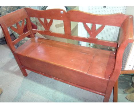 A red stained pine bench with lift top seat.  