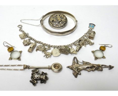 Mostly silver jewellery, comprising; an oval hinged bangle, on a snap clasp, a charm bracelet, a frog brooch, a brooch design