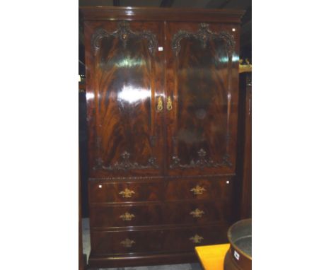 A 20th century mahogany two door wardrobe with applied carved decoration.