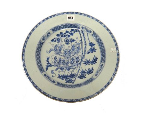 A large Chinese blue and white plate, Kangxi, painted in tbe centre with fruiting vine, flowers and bamboo inside a bianco-so