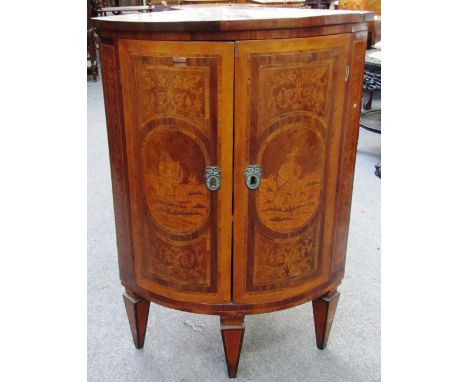 A 19th century Dutch floral marquetry inlaid rosewood and walnut floor standing bowfront two door corner cupboard, on taperin