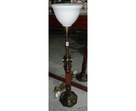 A 20th century walnut and brass uplighter lamp.