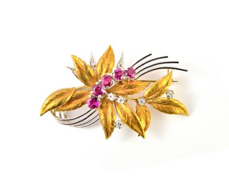 An 18ct two colour gold, ruby and diamond set brooch, designed as a foliate spray, claw set with a row of five circular cut r