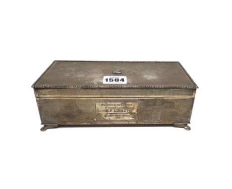 A silver rectangular table cigarette box, wooden lined within, the exterior engine turned, the cover applied with a crest, th