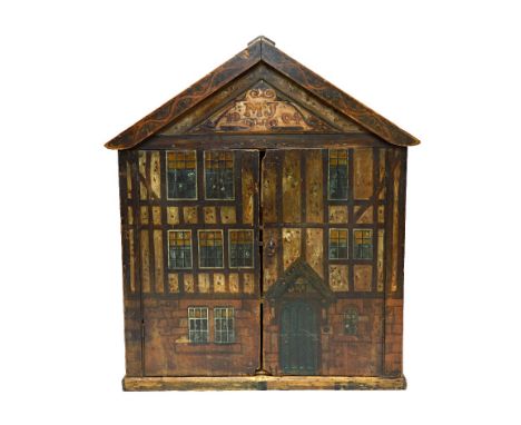 An early 20th century two door cupboard, with painted decoration depicting a timber framed three storey town house with pitch