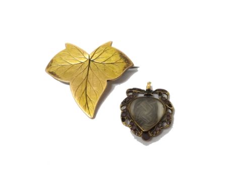 A gold and flat cut garnet set pendant locket, glazed with woven hairwork at the centre, within a scrolling surround, set wit