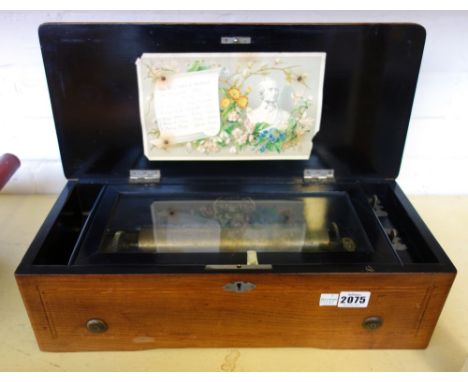 A Swiss walnut cased music box, late 19th century, the marquetry inlaid hinged lid opening to reveal a nine inch brass cylind