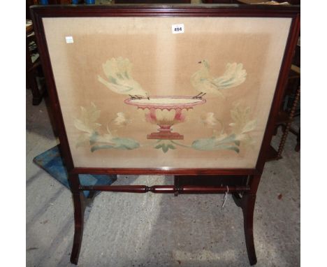 A mahogany fire screen with silkwork panel.