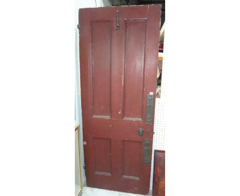 A red painted interior door with Art Nouveau copper panels.