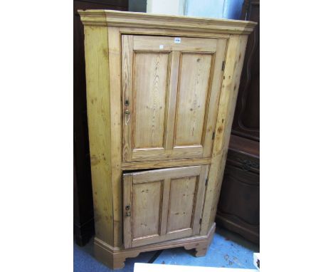 An early 19th century pine double height floor standing corner cupboard, on bracket feet, 100cm wide x 178cm high.