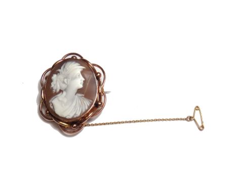 A gold mounted cameo brooch, carved as the portrait of a lady, within a beaded and looped surround, fitted with a safety chai