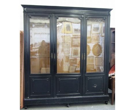 A 19th century ebonised three door display cabinet on turned supports, 210cm wide x 234cm high.