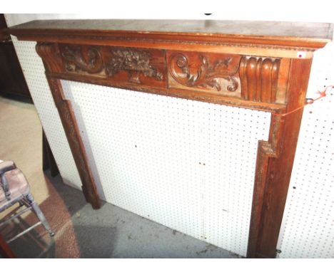 A 19th century pine fire surround with carved decoration.