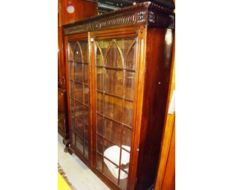 A 19th century oak two door glazed floor standing bookcase with carved decoration.