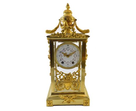 A French four glass mantel clock, late 19th/early 20th century, with urn finial over a foliate painted enamel dial, the glass