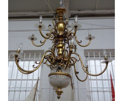 A pair of brass and cut glass twelve branch chandeliers, 20th century, the scroll arms graduated over two tiers with a cut gl