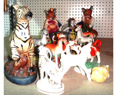 A quantity of assorted ceramic figures, including Staffordshire dogs, cow creamers, a Beswick elephant and sundry.