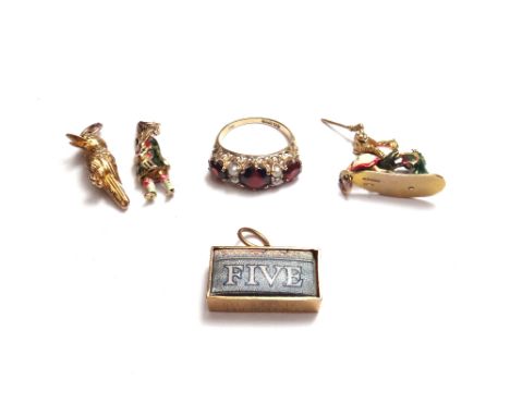 A 9ct gold ring, mounted with three circular cut garnets and with two pairs of seed pearls, mounted at intervals and four mos