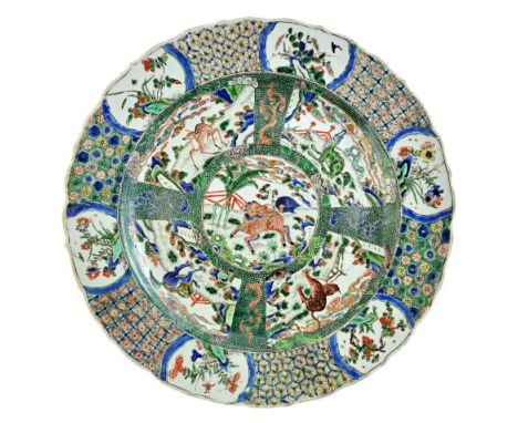 A pair of Chinese famille-verte chargers, Kangxi, each painted in the centre with a mythical creature running in a landscape,