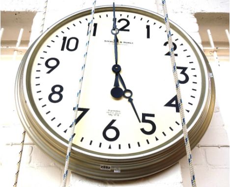 A modern circular wall clock with matte silvered circular frame, the painted dial detailed 'Sterling and Noble Clock Company'